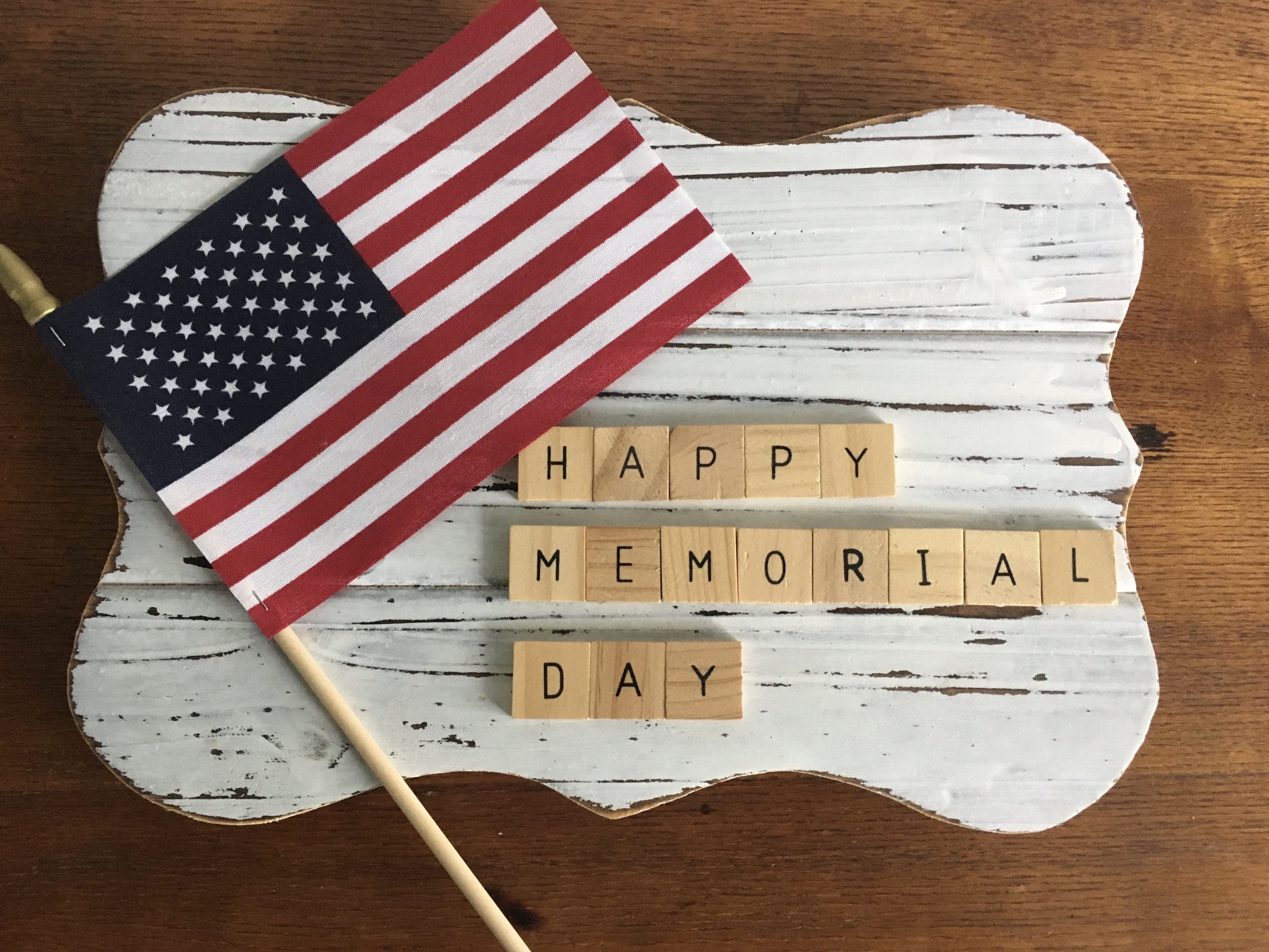 Bandera americana junto a azulejos que escriben Happy Memorial Day